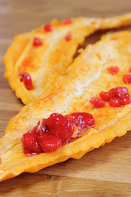 縦に２つに切られた完熟ゴーヤ、赤い種子のアップ