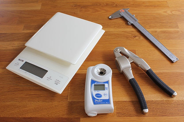 床に測定機器が並べられている、秤、糖度計、果汁採取用搾り器、ノギス